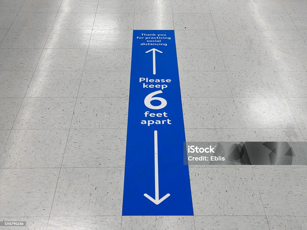 Social distancing floor sign warning about safe distance between people of 6 feet. Public health measure to prevent further spread of new corona virus Covid-19 infections. Social Distancing Stock Photo