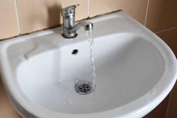 istock Bathroom sink and faucet with running water 1215796991