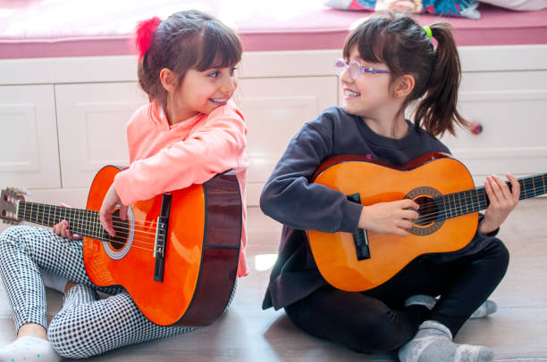istock Cute girls playing guitar 1215798568