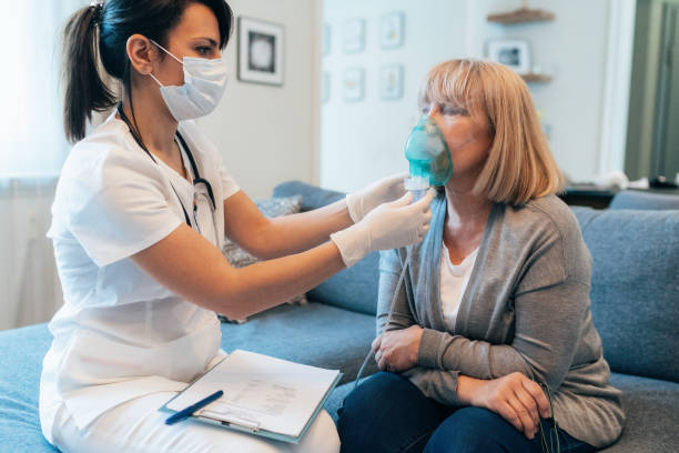 Doctor's home visiting during the quarantine Medical doctor applying medicine inhalation treatment on senior woman by the mask of inhaler during coronavirus quarantine breath vapor stock pictures, royalty-free photos & images