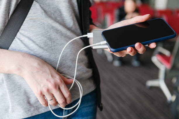 istock Female hands with smartphone and power bank 1215798901