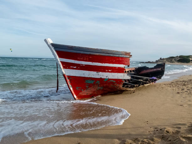 istock Red boat with white lines on the beach 1215799833