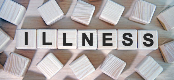 istock ILLNESS - text wooden cubes and many cubes around 1215799851