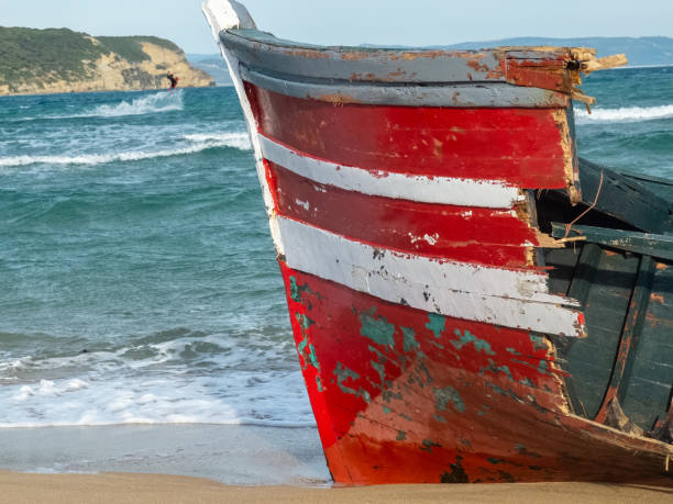 istock Red boat with white lines on the beach 1215799930