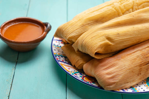 istock Mexican tamales with red sauce on turquoise  background 1215801550