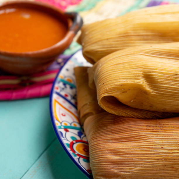 istock Mexican tamales with red sauce on turquoise  background 1215802641