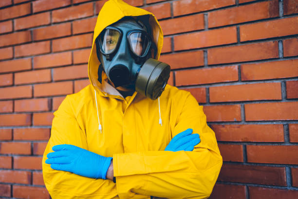 istock Man in a protective suit and gas mask in front of a wall 1215802743