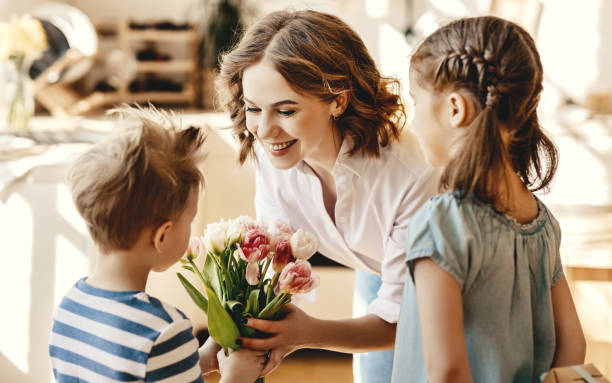 istock Little children congratulating mother in kitchen 1215803551