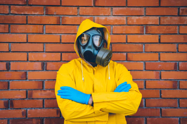 istock Man in a protective suit and gas mask in front of a wall 1215803619