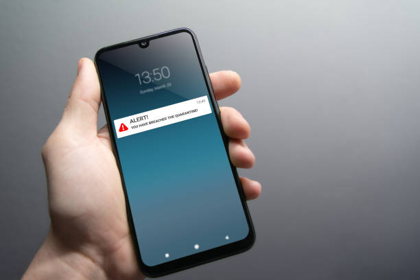 istock Quarantine breach alert mockup on smartphone being held by male hand 1215803909