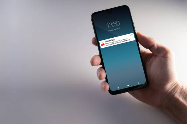 istock Quarantine breach warning notification mockup on smartphone held by male hand 1215803933