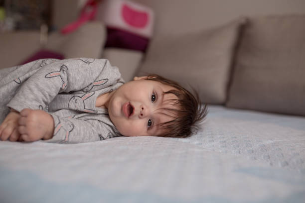 istock Baby girl smiling on a bed 1215804128