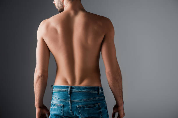rückansicht von sexy hemdsärmeligen mann in jeans auf grau - nackter oberkörper stock-fotos und bilder