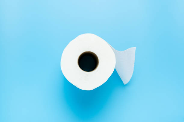 Single toilet paper roll One toilet paper roll isolated on blue background toilet paper photos stock pictures, royalty-free photos & images