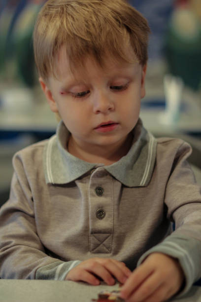 istock blond boy makes a picture from the puzzle. 1215806505