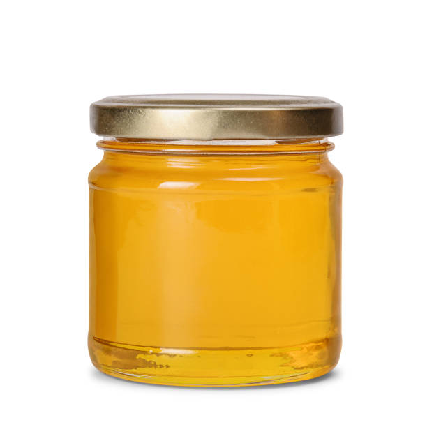 istock Glass jar full of honey on white background 1215807196