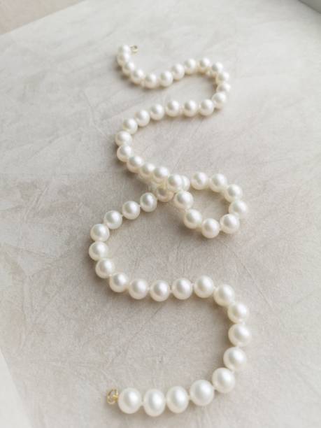 istock White pearl necklace on velvet 1215807206