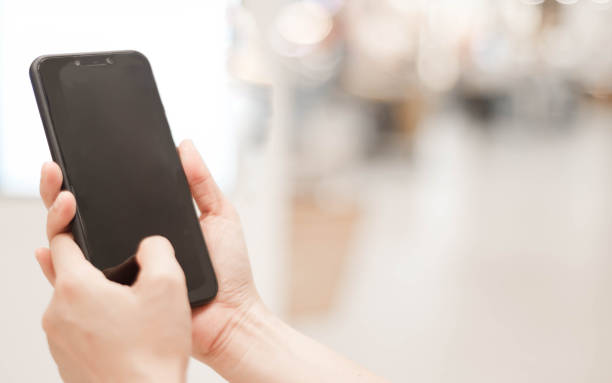 istock Female hands holding smart phone with blank blank screen for text message or information content, smartphone 1215807367