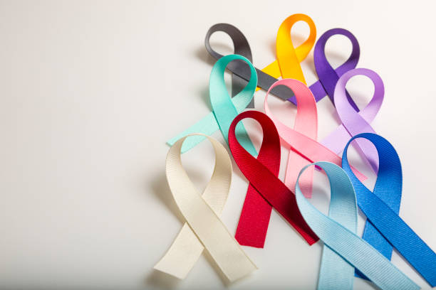 世界の癌の日のために患者、支持者および生存者が誇らしげに身に着けている多色の癌のリボン。あらゆる種類のがんに対する意識を高める - cancer ストックフォトと画像