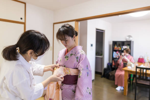 istock Young woman wearing kimono at home 1215818433