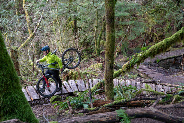 istock Mountain biker carries bike up boardwalk 1215819836