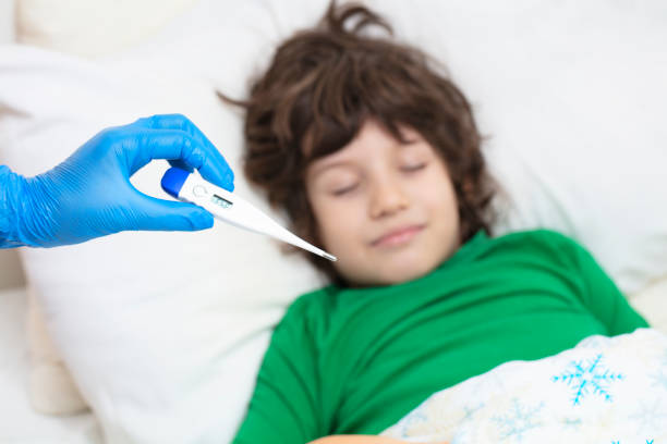 istock Child thermometer,Doctor checking on sick little boys temperature 1215820721