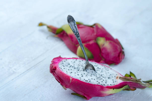 istock Two halves of dragon fruit with spoon on white background, tropical fruit 1215821610