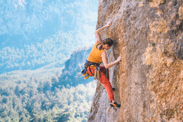 istock Girl climbs a rock. 1215821676