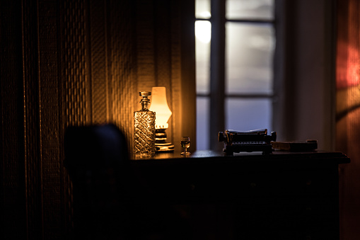 A realistic dollhouse living room with furniture and window at night. Artwork table decoration with handmade realistic dollhouse. Selective focus.