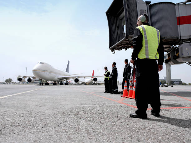 lavoratori di terra aeroportuali - passenger boarding bridge foto e immagini stock