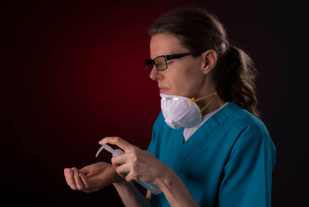 istock COVID-19 healthcare worker using PPE protective equipment and hand sanitizer 1215832461