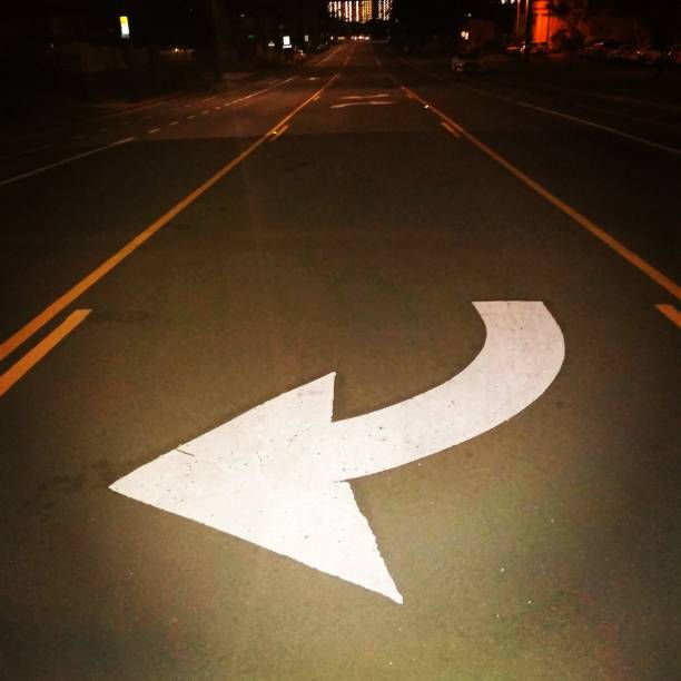 istock Close up desolate street white arrow left turn 1215833180
