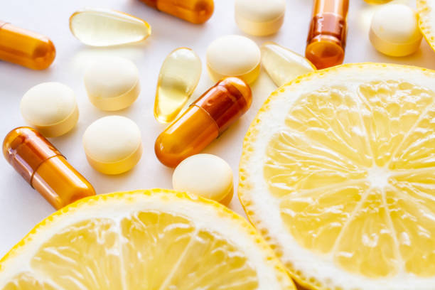 suplementos vitamínicos y limón fresco - vitamin a nutritional supplement pill capsule fotografías e imágenes de stock