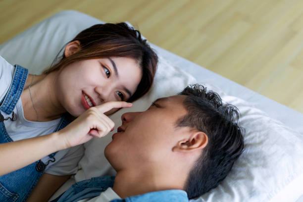 istock Romantic young woman looking at man in bed 1215838681