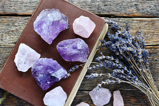 A top view image of amethyst and rose quartz crystals with dried lavender flowers.