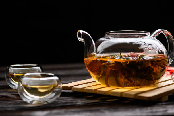 istock Teapot and glass cup with blooming tea flower 1215841576