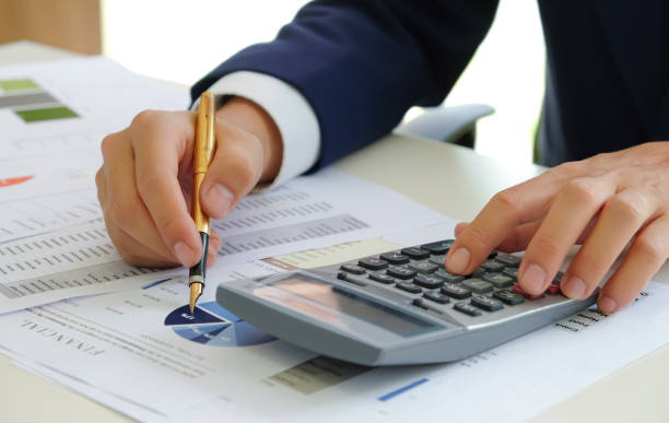 istock Cropped shot of Analysts use calculators and pointers on graphs to assess the fluctuating stock market situation. 1215850530