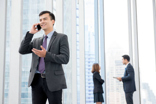 istock Businessman calling on smartphone at office building hallway 1215851945