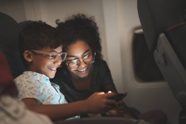Children using smart phone during the flight stock photo