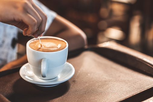 Drawing on coffee foam in rustic coffee shop