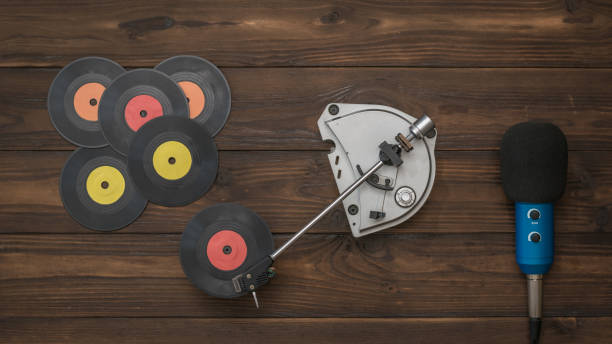 istock A microphone with a wire and a player with vinyl discs on a wooden background. 1215852135