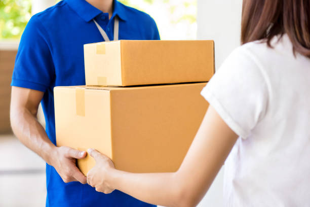istock Deliveryman giving parcel box to a woman 1215853849