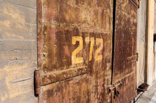 istock Old weathered rusty factory gate with number 1215855323