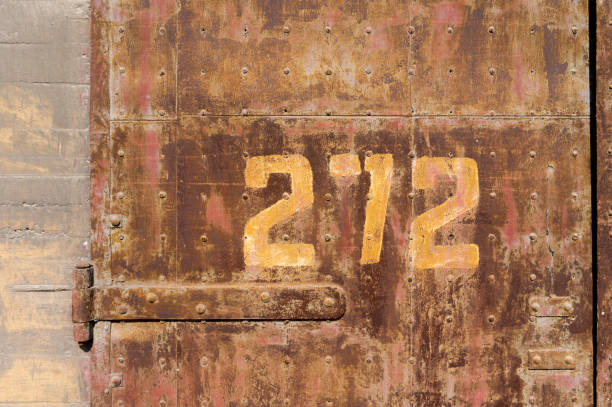 istock Old weathered rusty factory gate with number 1215855342
