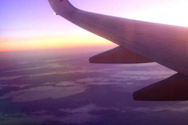 istock wing of an airplane flying in backlight at sunset 1215856072