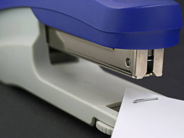 istock close up of blue stapler with stapled paper 1215856324