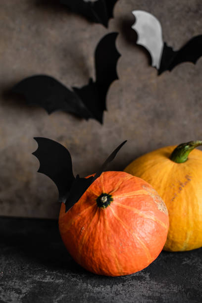 istock Halloween pumpkins and bats on a dark background 1215856325