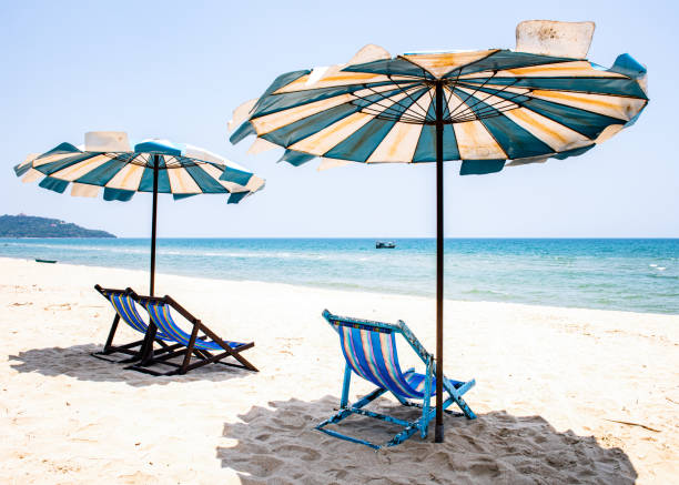istock Beach Holiday scene relaxing in deck chairs. 1215858689
