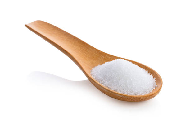 istock sugar in wooden spoon on white background 1215859947