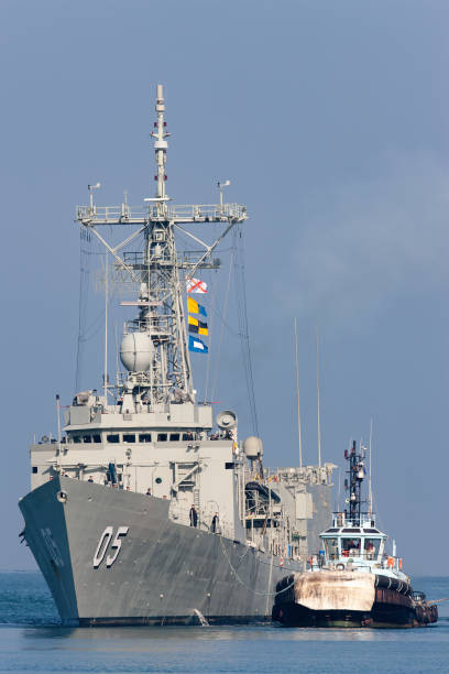 hmas melbourne (ffg 05) adelaide-class guided-missile frigate of the royal australian navy docking at station pier in melbourne with the assistance of tug boats. - tug o war imagens e fotografias de stock